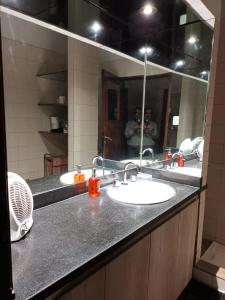 a bathroom counter with two sinks and a mirror at Hospedaje Gustavo in Ezeiza +3 photos