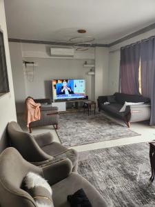a living room with couches and a flat screen tv at الامارات in Al Ma‘şarah