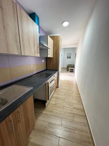 a kitchen with wooden cabinets and a wooden floor at Rooms Getafe in Getafe