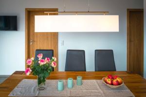 a table with a vase of flowers and a bowl of apples at Ferienwohnung Weitblick in Bruchweiler-Bärenbach +50 photos