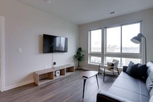 a living room with a couch and a tv on a wall at Apartment just 15 minutes walk from the Metro in Alexandria