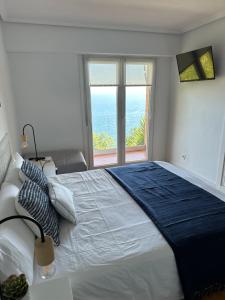 a bedroom with a large bed with a large window at PIPER ETXEA......Relax, mar y monte! in Mutriku