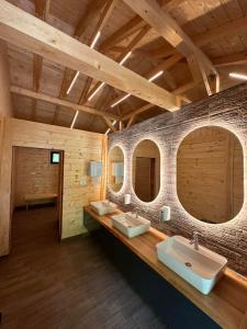 a bathroom with two sinks and two mirrors at Rafting Camp Tara 87 in Hum