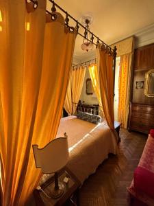 Schlafzimmer mit einem Bett mit orangefarbenen Vorhängen in der Unterkunft Villa Puccini in Venegono Superiore