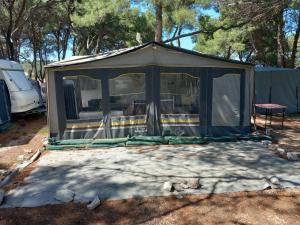 um gazebo com uma mesa e uma cadeira em Caravan near the sea 5 em Ugljan