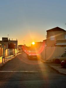 a row of cars parked on a street at sunset at CASA JARDIN DE MAR in Torrevieja