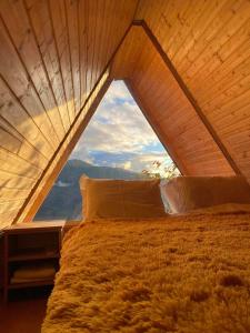 łóżko w pokoju z dużym oknem w obiekcie cottage panorama merisi w mieście Inasharidzeebi