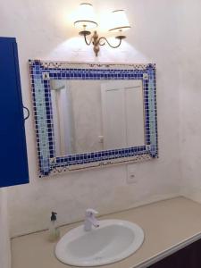 une salle de bain avec un lavabo et un miroir dans l'établissement Château de Busqueilles - La Couple, à Autoire
