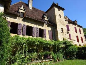 un vieux bâtiment en pierre avec un tas de fenêtres dans l'établissement Château de Busqueilles - La Couple, à Autoire