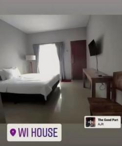 a hotel room with a bed and a desk at WiHouse Bali in Denpasar