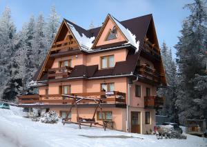 a large building with snow on the ground at Willa Piękne Widoki in Ząb