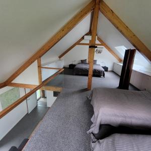 a attic room with two beds and a window at Kromven in Merksplas