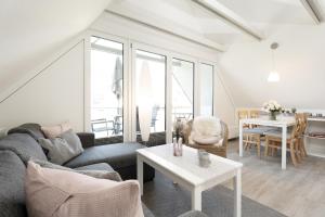 uma sala de estar com um sofá e uma mesa em Badeweg 4 Haus Bullerbü, App 10 em Scharbeutz