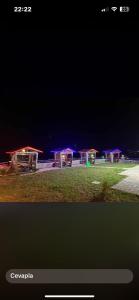 a group of picnic tables in a field at night at Azhara Bungalov in Pelitli