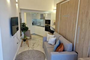 een woonkamer met een bank en een keuken bij Beachfront Studio-Hosted by Sweetstay in Gibraltar