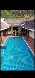 a large blue swimming pool in a building at Golden Sun Ray's Villas in Baga