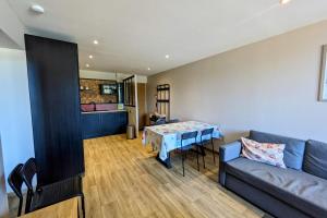 ein Wohnzimmer mit Sofa und Tisch in der Unterkunft La feclaz - Magnifique appartement 6 personnes in La Feclaz