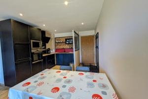 eine kleine Küche mit einem Bett in einem Zimmer in der Unterkunft La feclaz - Magnifique appartement 6 personnes in La Feclaz