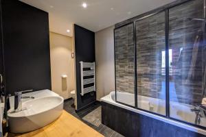 ein Badezimmer mit Badewanne und Waschbecken in der Unterkunft La feclaz - Magnifique appartement 6 personnes in La Feclaz