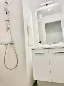 a white bathroom with a shower and a sink at Chambre Confort - Douche Privative - Jardin - Parking Gratuit in Argenteuil