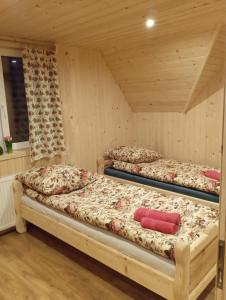 three beds in a room with wooden walls at Domek na Bachledowce 2 in Leszczyny