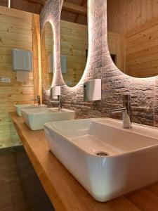 a bathroom with three sinks and two mirrors at Rafting Camp Tara 87 in Hum