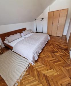 - une chambre avec un grand lit et du parquet dans l'établissement Apartmani Zinda, à Sukošan
