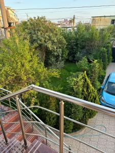 uma varanda com corrimão e árvores e um carro em Akid&Alan Apartment em Tirana