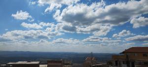 uma vista para um céu azul com nuvens em Kit net montanha mágica em São Thomé das Letras