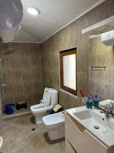 uma casa de banho com um WC e um lavatório em Akid&Alan Apartment em Tirana