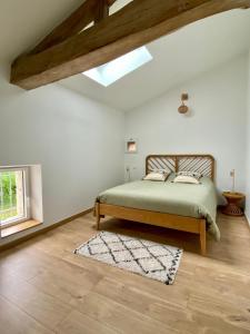 1 dormitorio con cama, ventana y alfombra en Les figuiers de Jeanne, en Castelculier