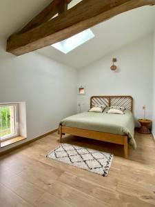a bedroom with a bed and a window and a rug at Les figuiers de Jeanne in Castelculier +23 photos
