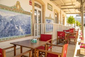 un ristorante con tavoli e sedie e un grande dipinto sul muro di Lousã Estação AL a Coimbra