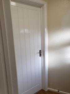 a white door with a silver knob in a room at Glorioushome in Basildon