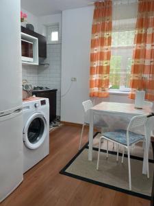 a kitchen with a table and a washing machine at Apartament Nich in Mangalia