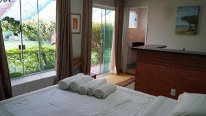 a room with a bed with four towels on it at Pousada Mangas in Manguinhos