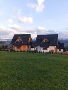 une maison sur une colline avec un champ vert dans l'établissement Domek na Bachledówce, à Czerwienne