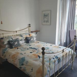 a bedroom with a bed with a floral comforter at Chynoweth Lodge in Newquay