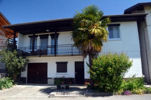 una palmera frente a una casa blanca en Hiša v Travniku, en Šmartno