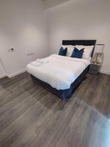 um quarto com uma cama grande e almofadas azuis em Charming 3-Bed Apartment in London em Londres