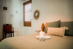 een slaapkamer met een bed met handdoeken erop bij Boho Oasis by the Beach in San Juan