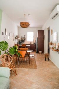 Boho Oasis by the Beach في سان خوان: غرفة معيشة مع طاولة وكراسي ومطبخ