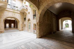 an empty courtyard of an old building with arches at Tomasi Apartment Palermo in Palermo