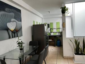 a kitchen and dining room with a glass table at Sumaq AirPort in Lima