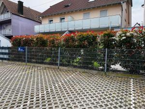 a fence in front of a house with flowers at Hotel Sonne in Neuburg