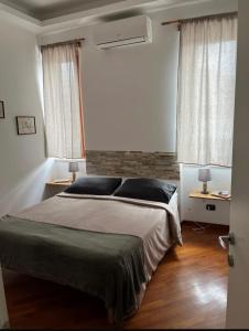 um quarto com uma cama grande e 2 janelas em La Ville em Torre del Greco
