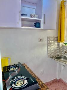 a kitchen with a stove and a counter top at Cozystay in Nakuru