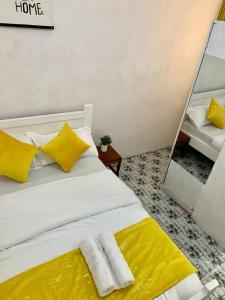 a bedroom with a bed with yellow pillows and a mirror at Cozystay in Nakuru