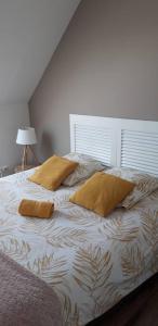 a bed with two pillows on it in a bedroom at gite la fécampoise près de Fécamp in Ganzeville