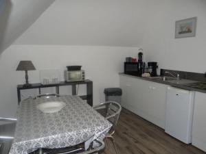 a kitchen with a table and a counter with a sink at Gîte pour 2 personnes le domaine de la roquette près de fécamp à ganzeville in Ganzeville +17 photos